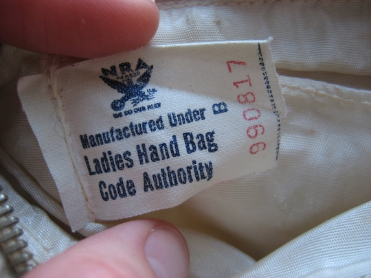 NRA Blue Eagle Label fingers holding a 1930s nra blue eagle label